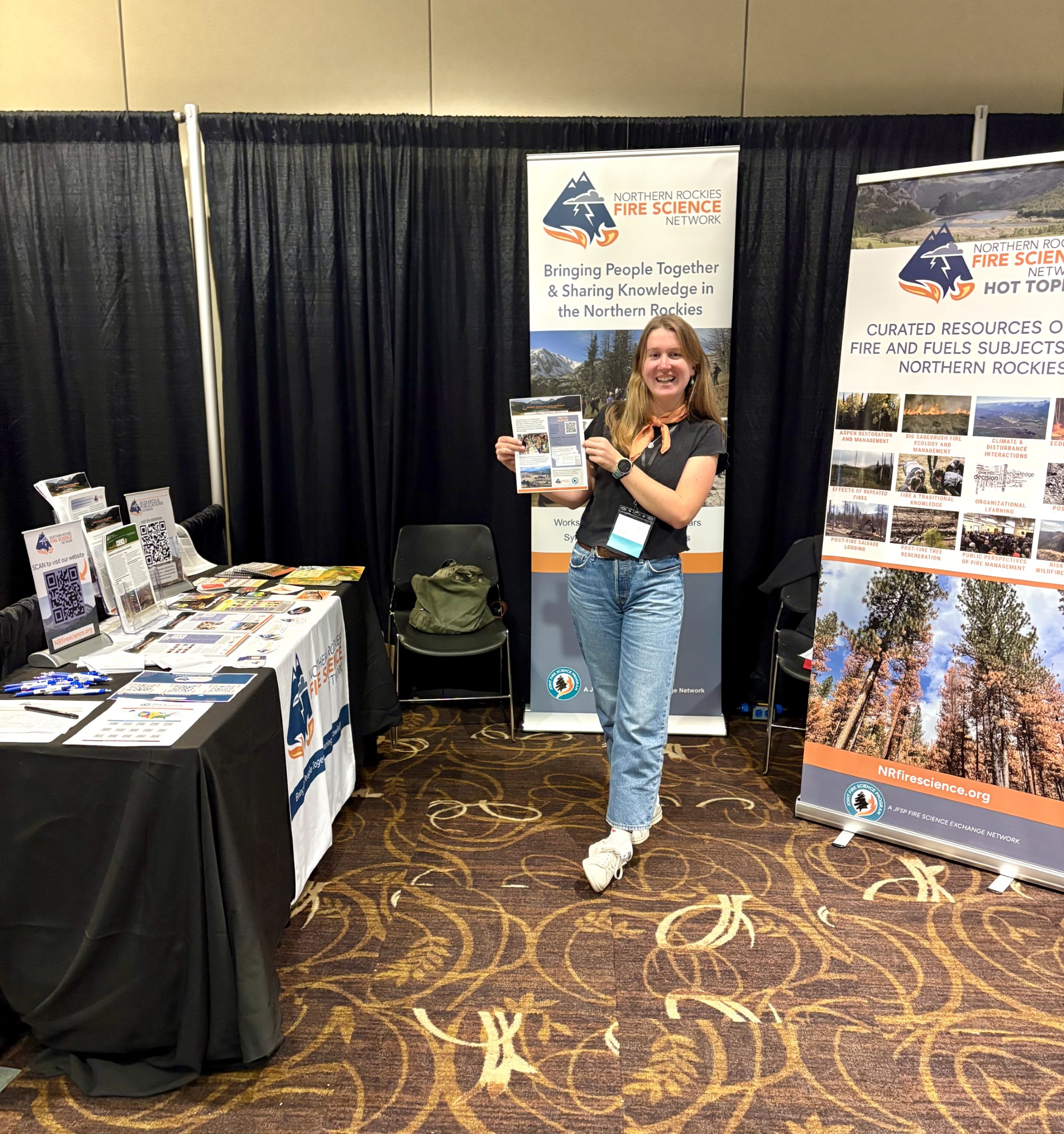 girl stands in front of two promotional banners, holding a piece of paper
